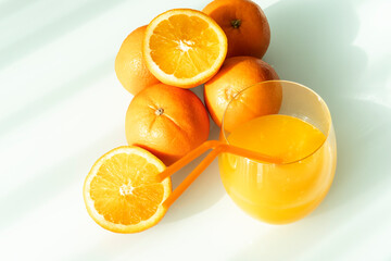 Orange juice in a glass with some oranges around