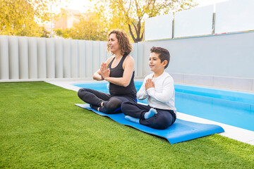 Mother and son doing yoga exercises in their home garden