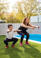 Mother and son doing exercise in their home garden