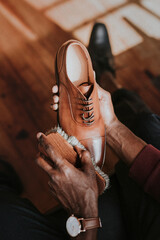 Man applying shoe polish to his brown leather shoes