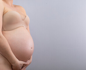 Pregnant woman is holding her belly