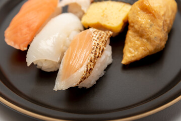 黒いお皿に盛り付けられた握り寿司