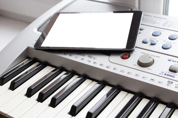 Mockup piano online courses. Tablet with place for text laying on the electric piano