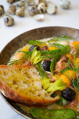 Delicious homemade quail egg omelette with tuna and olives. Served with toasts. 