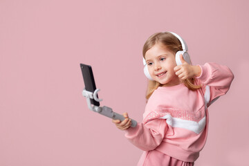 Little girl blogger influencer records videos from the blog on a smartphone, communicates with subscribers, puts likes, listens to music with headphones, remote learning on an isolated background.