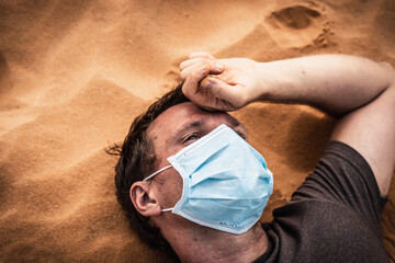Side portrait man wear protective mask, face expression emotion lies on back, hand on forehead....