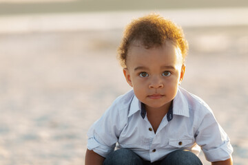 Portrait of little biracial boy. Cute mixed race little kid having fun on a beach vacation. Looking at Camera Serious Facial Expression Head Shot