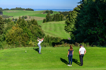 Familien-Flight beim Abschlag auf einem herrlich gelegenen Golfplatz