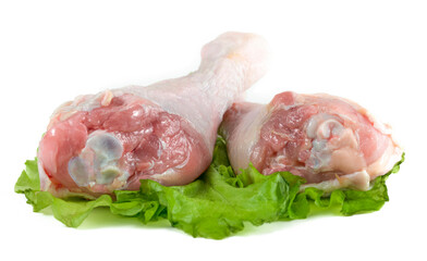 Raw chicken legs and green salad isolated on white background.