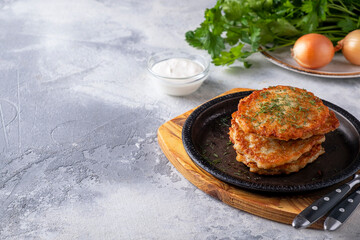 Potato pancakes on a frying pan. Copy space