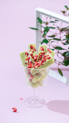 Fudge, sweet candies, handmade dessert made of white chocolate, matcha tea and strawberries on a bright background.