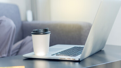 Fototapeta premium A coffee mug on a businessman's laptop for drowsy drinking