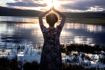 Fototapeta premium Girl on her back with the sun and hands up