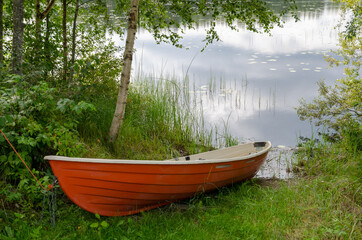 Small red boat on the coast lake Petajavesi Finland forest landscape