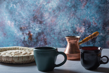 Two mugs and a coffee turk. Coffee composition on the table.