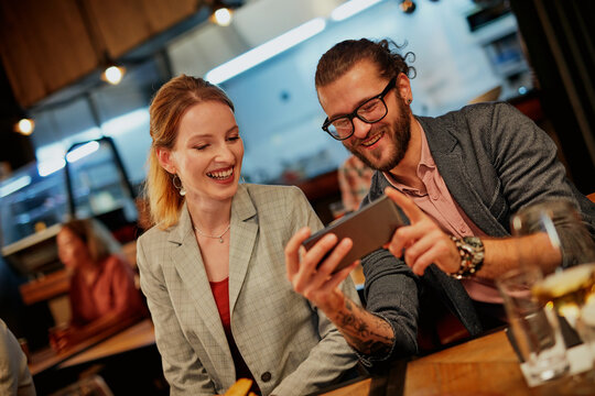 Attractive hipster couple sitting in a restaurant and taking a selfie. It's a diner time.