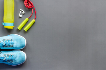 Flat lay of fitness gym equipment with sneakers and bottle of water