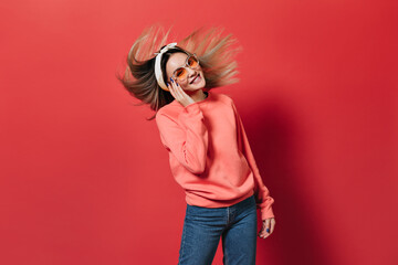 Woman in excellent mood plays hair on red