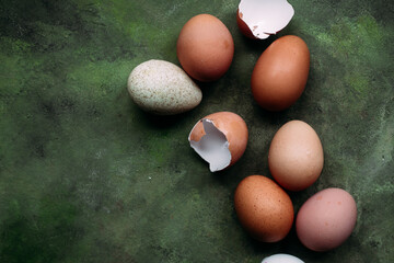 Brown and white chicken eggs on olive background