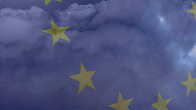 Digital animation of rain in night sky against waving eu flag