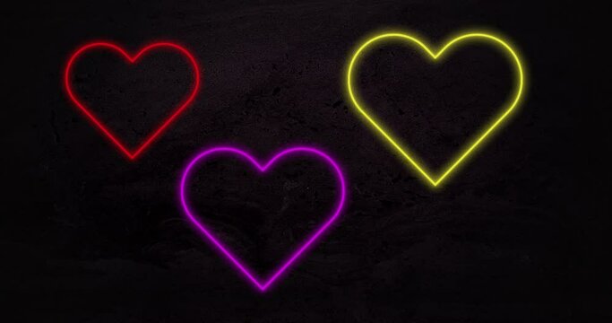 Animation of red purple and yellowneon hearts flashing on black background