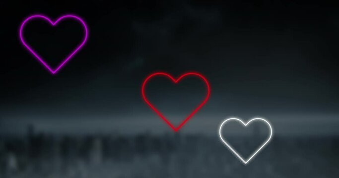 Animation of red pink and white neon hearts flashing on dark background