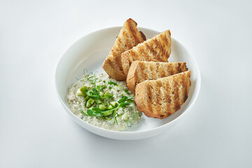 Classic dish of Israeli cuisine - herring forshmak with croutons in a white plate on a white plate
