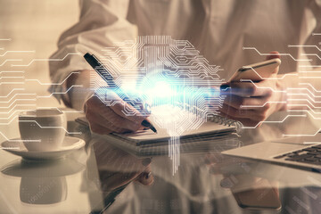 Double exposure of brain sketch hologram and woman holding and using a mobile device.