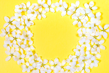 Round frame made of white apple tree flowers on trendy yellow Illumination background. Festive layout for spring holidays. Valentine's Day, Mother's Day, Birthday. Top view, copy space for text.