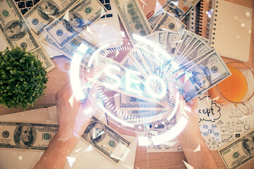 Multi exposure of seo drawing hologram and us dollars bills and man hands.