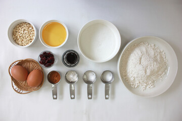Baking Cooking And Cake Ingredients Flour Eggs Vanilla Powder Bowl Whisk Spatula Butter Cinnamon Powder And Kitchen Textile On White Table Background. Top View. Cookies Pie Or Cake Recipe Mockup