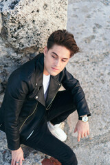 Handsome, serious young man outdoors thinking, looking to the side, reflecting.