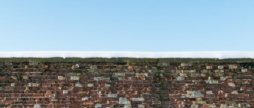 A fragment of a brick wall with snow