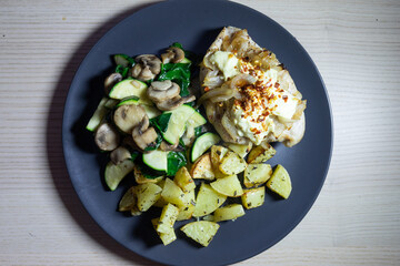 Baked chicken with potatoes and vegetables.