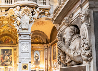 Fototapeta na wymiar View of interior decoration of catholic church in Rome, with marble statues of saints carved on marble walls