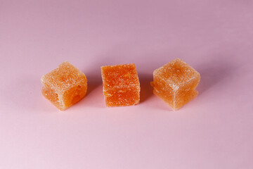 Peach marmalade on pink background. Delicious, juicy homemade sweets