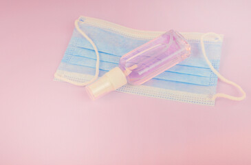 Antiseptic spray for disinfection, hand sanitizer bottle on a pink background with Blue musk.Copy space for text. Cleanser product.  Theme of medicine and cosmetology with white light