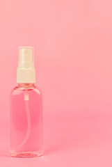 Antiseptic spray for disinfection, hand sanitizer bottle on a pink background with copy space. Cleanser product. Protection against viruses, covid-19