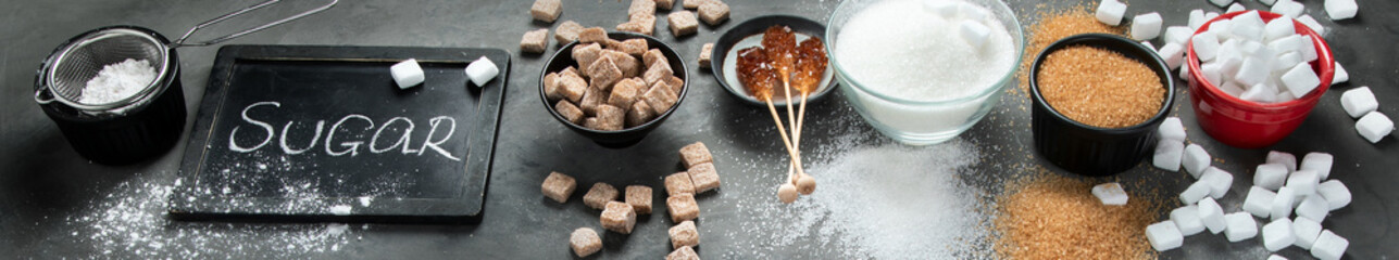 White and brown sugar on dark background