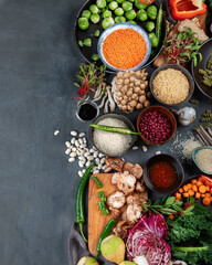 Asian raw vegan food, grain, seeds and vegetables on dark background