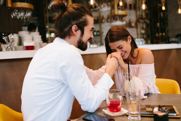 Young happy couple at a date in a coffee shop