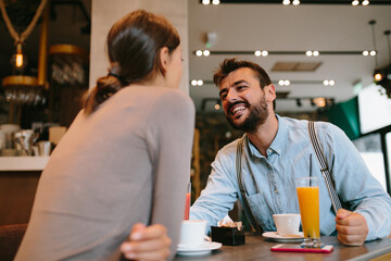 Young happy couple at a date in a coffee shop