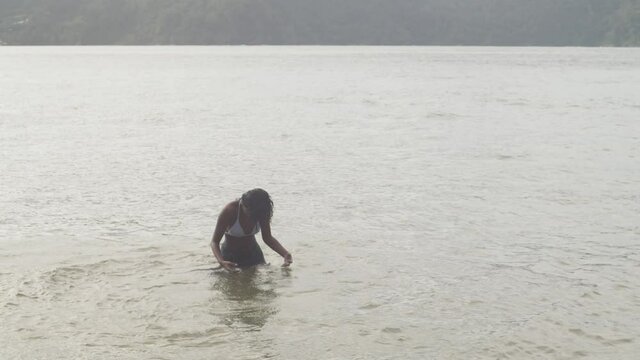 A young girl dancing happily in the warm Caribbean sea