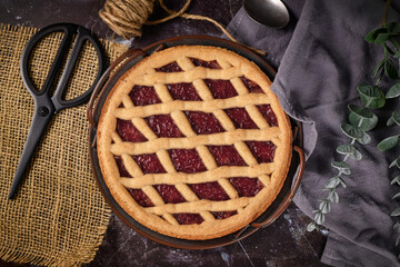 Top view of homemade pie called 'Linzer Torte', a traditional Austrian shortcake pastry topped with fruit preserves and sliced nuts with lattice design 