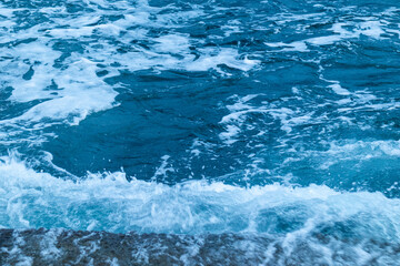 beautiful, blue sea with big, high waves, foam in a storm in the evening