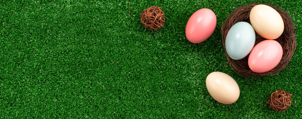 Colorful Easter eggs in the nest on a lawn with pink Double Lily flower.