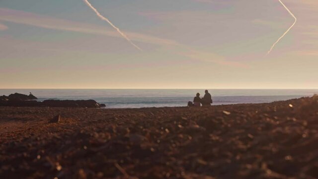 Older Couple Watching The Ocean Waves At The Beach