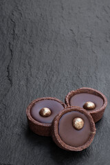 Molten Chocolate Caramel truffles decorated with golden drip on stone background