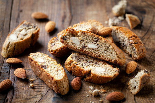 Homemade gluten free biscotti or cantuccini made of buckwheat flour with almonds and chocolate chips on dark rustic wooden background