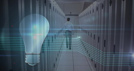 Animation of lightbulb icon over caucasian man working in a server room - Powered by Adobe